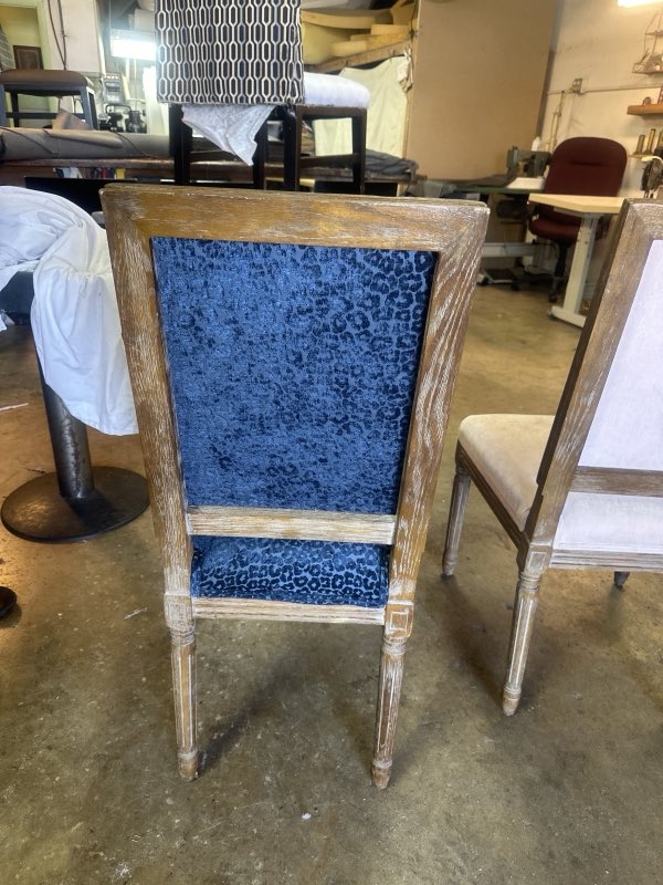 Back of a dining chair upholstered in blue crushed velvet leopard fabric