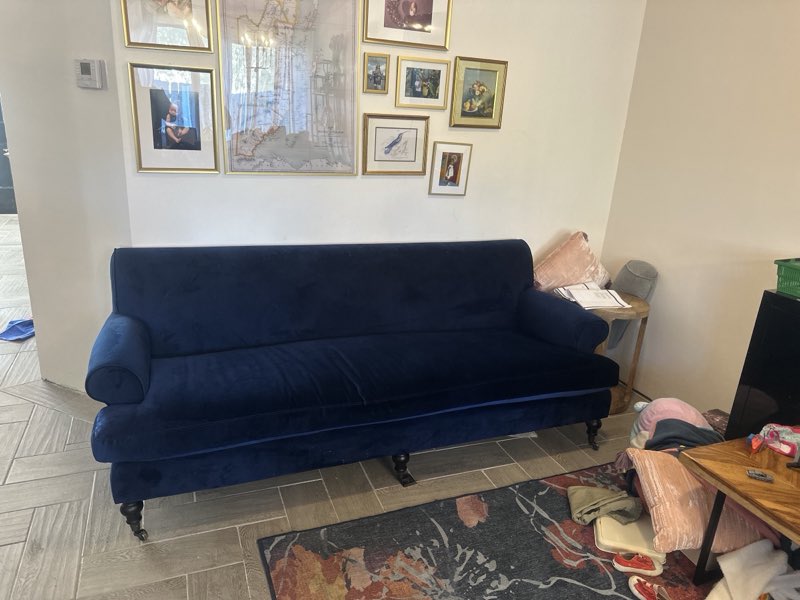 Navy blue velvet sofa reupholstered and placed in a living room